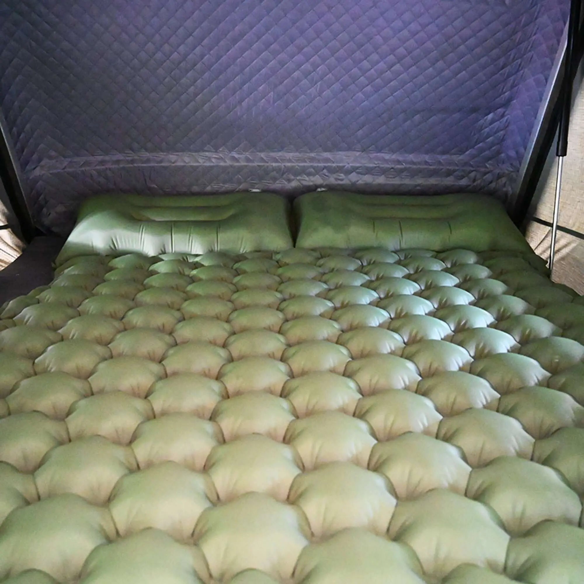 Comfortable inflatable rooftop tent mattress for camping, featuring built-in cushions and spacious design for up to two people.