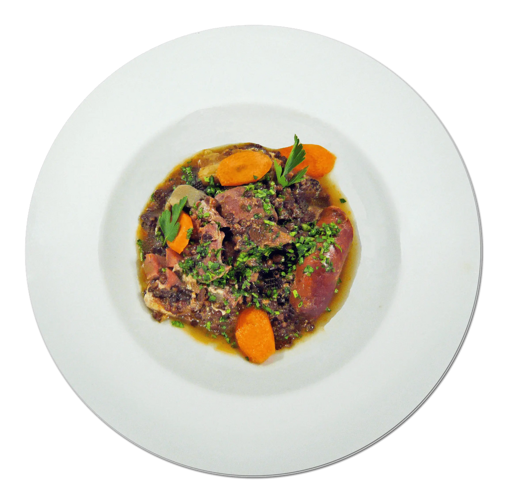 Petit salé aux lentilles Beluga dish on a white plate, featuring slices of meat, lentils, and garnished with herbs and vegetables.