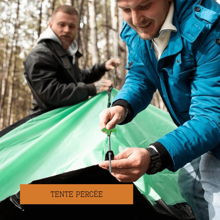 Deux personnes montent une tente verte dans la forêt, montrant une installation facile avec des sardines.
