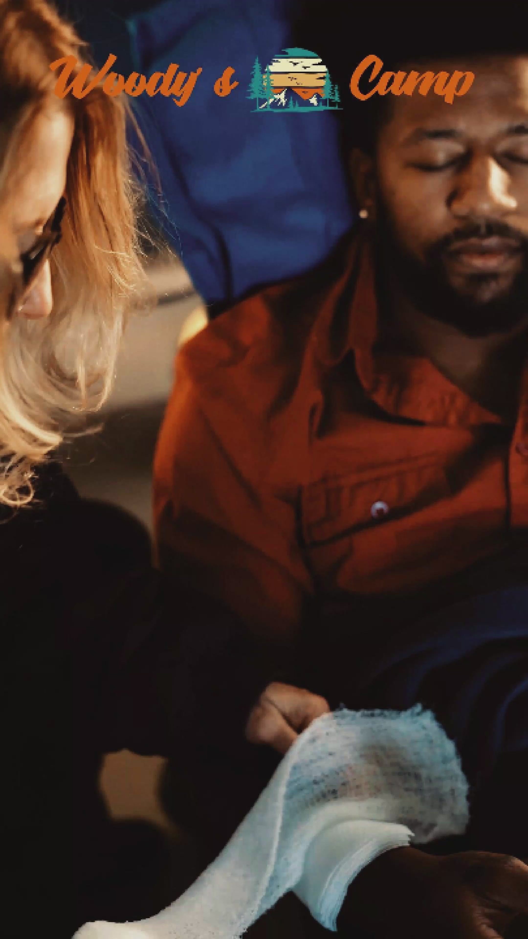Person using a first aid kit during a camping trip with 
