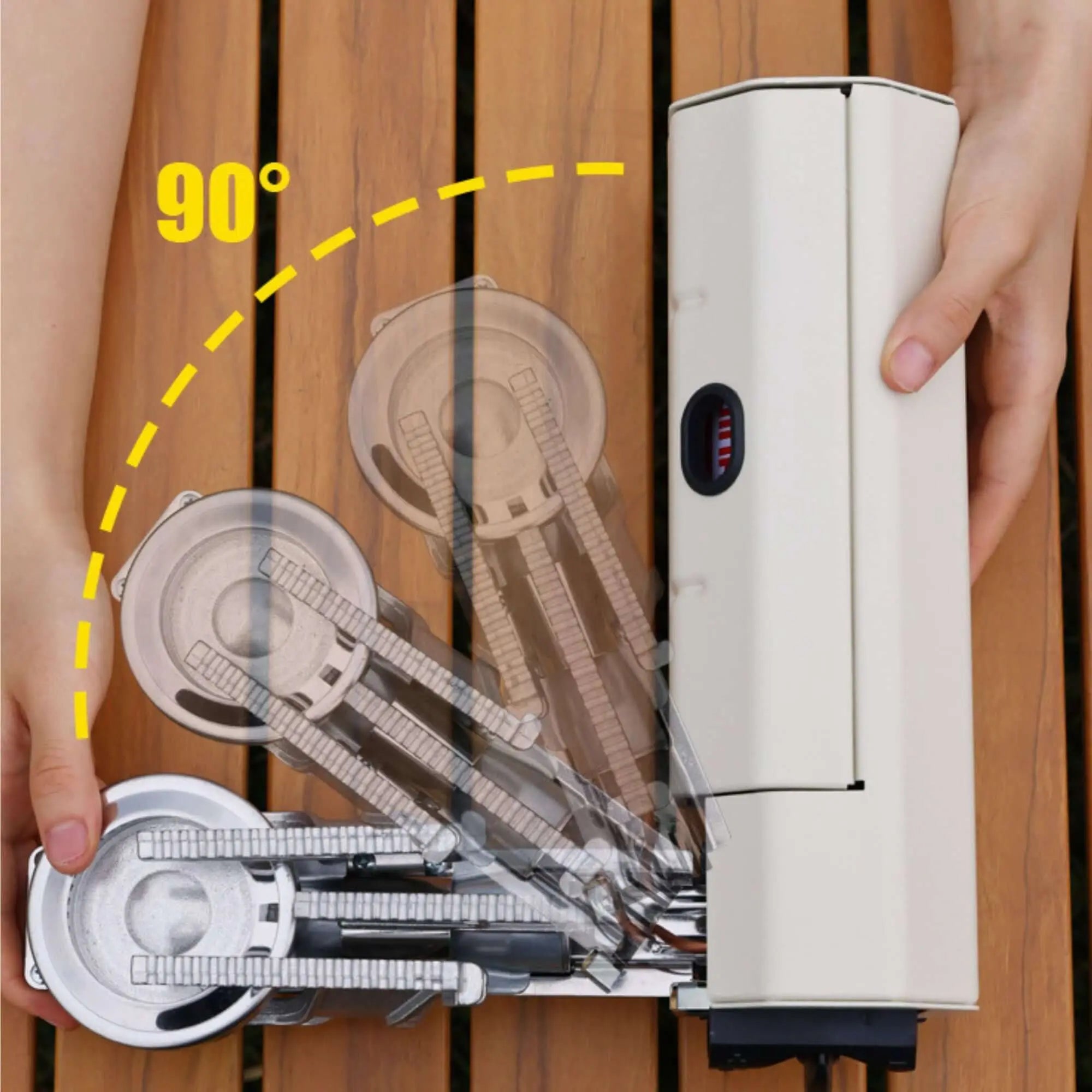 Hands folding a portable camping stove with a 90-degree mechanism, showcasing its compact design for outdoor cooking.
