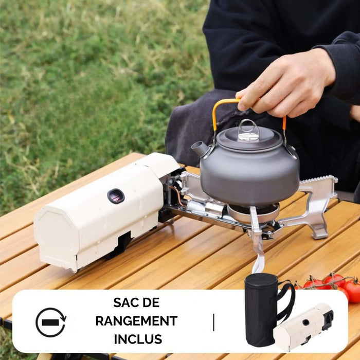 Réchaud de camping pliant portable sur une table en bois avec une bouilloire, idéal pour les aventures culinaires en plein air. Comprend un sac de rangement.