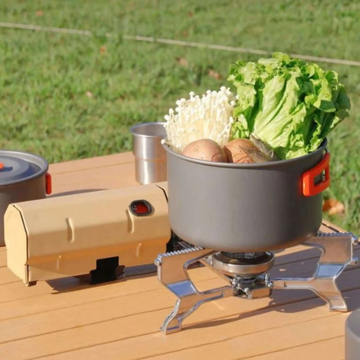 Un réchaud de camping pliable avec une casserole pour cuisiner des légumes frais en plein air, idéal pour le vanlife et les aventures de randonnée.