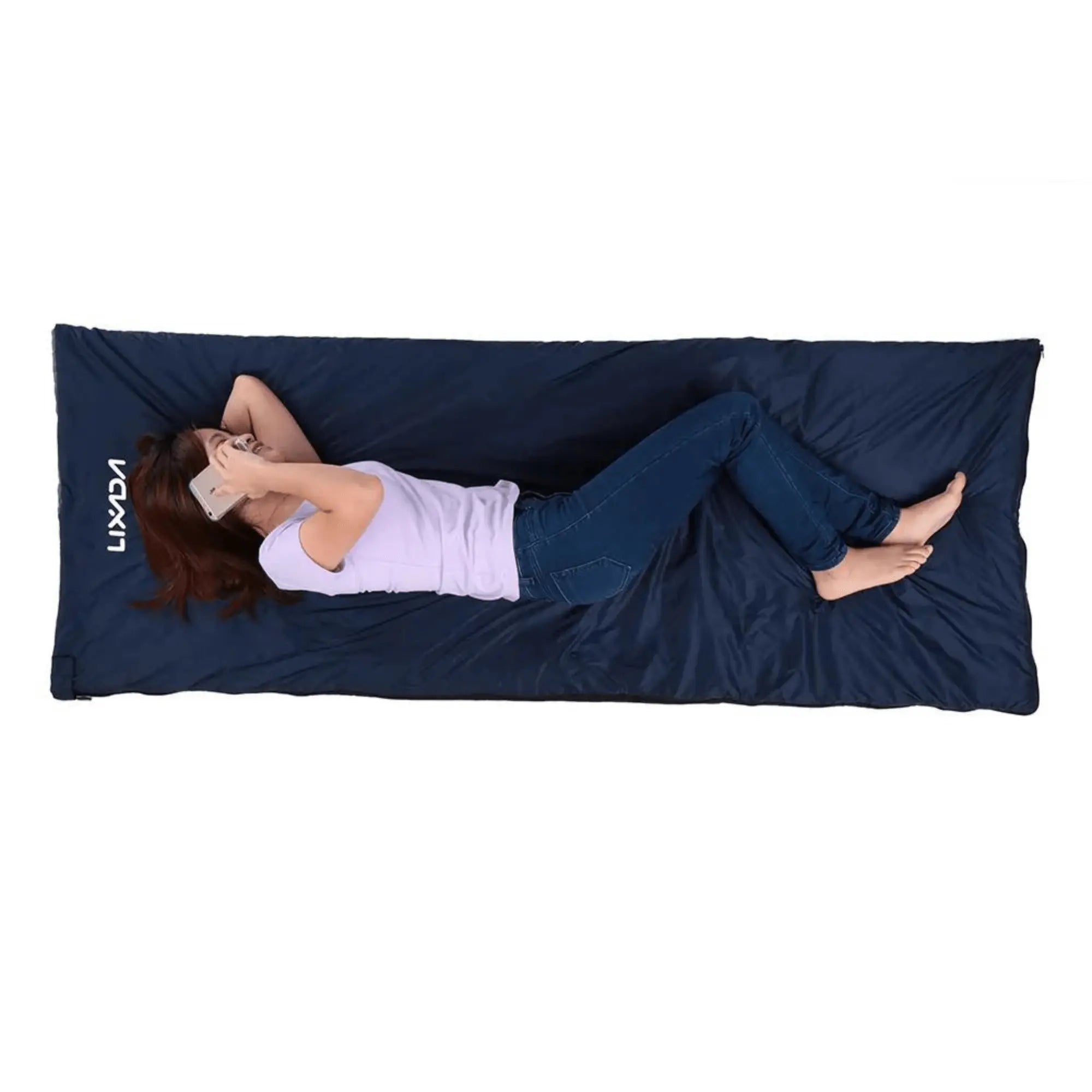 Person lounging on a dark blue ultralight outdoor sleeping bag, ideal for camping and hiking, providing comfort and warmth.