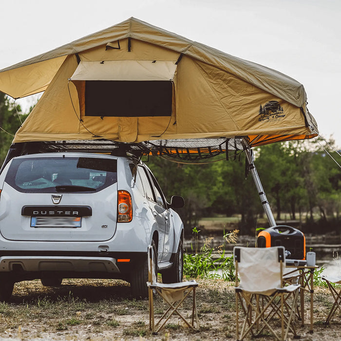 SUV avec tente de toit montée et équipement de camping dans un cadre naturel