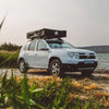SUV avec une couverture de tente de toit stationné au bord d'un lac, mettant en avant une housse en PVC résistante aux intempéries pour tentes sur toit de 3 et 5 places.
