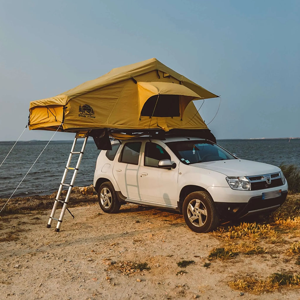 Roof tent mounted on a white SUV by the seaside, ideal for 2-3 people, offering comfort for outdoor adventures and road trips.