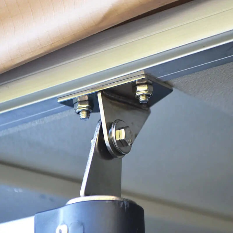 Close-up of a mounting bracket for a soft rooftop tent, showing screws and metal support.