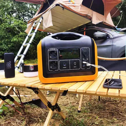 Portable battery kit with 1200WH capacity and solar panels on a camping table, ideal for travel and outdoor adventures.