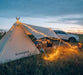 Guirlande LED solaire/USB illuminant une tente de toit et un camping-car au crépuscule, créant une atmosphère chaleureuse et conviviale.