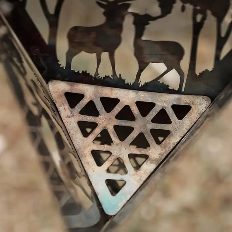 Triangular fire pit grill with intricate cutout design for camping and outdoor cooking, featuring wildlife silhouette.