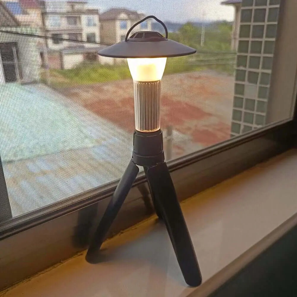 Rechargeable solar USB camping lantern on a window ledge, ideal for outdoor adventures with 100 LED lights and energy-saving design.