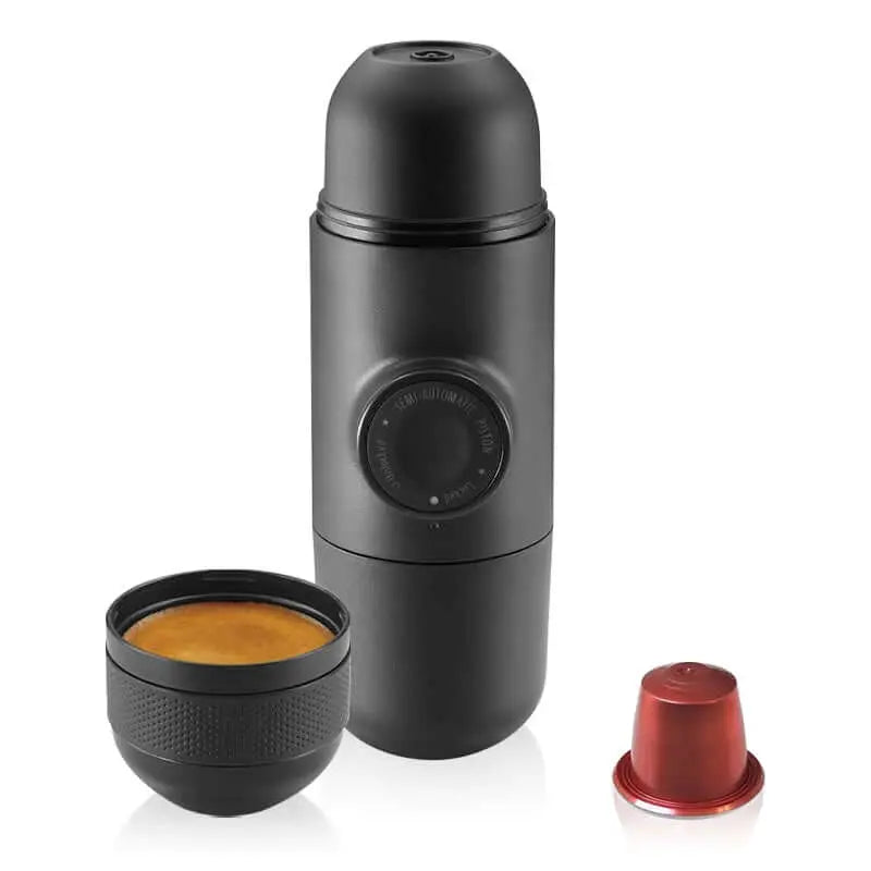 Portable Nespresso capsule coffee maker with espresso cup and capsule, ideal for camping and outdoor use, compact and lightweight design.