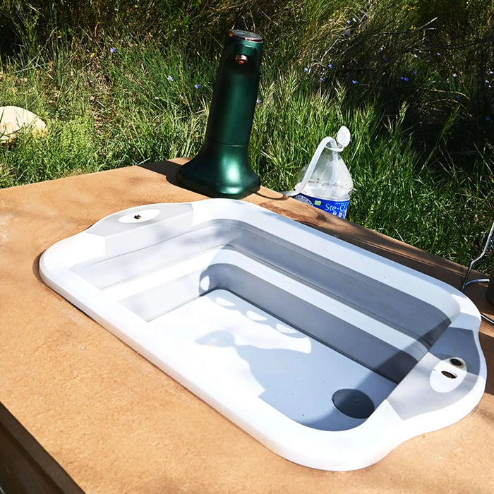 Évier de camping pliable en silicone compact sur table de plein air
