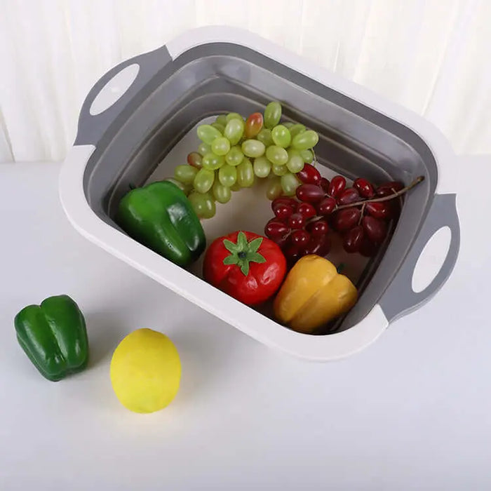 Évier pliable en silicone rempli de fruits et légumes, idéal pour le camping et la cuisine mobile.