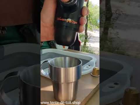 Portable Nespresso coffee maker preparing espresso outdoors for camping enthusiasts.