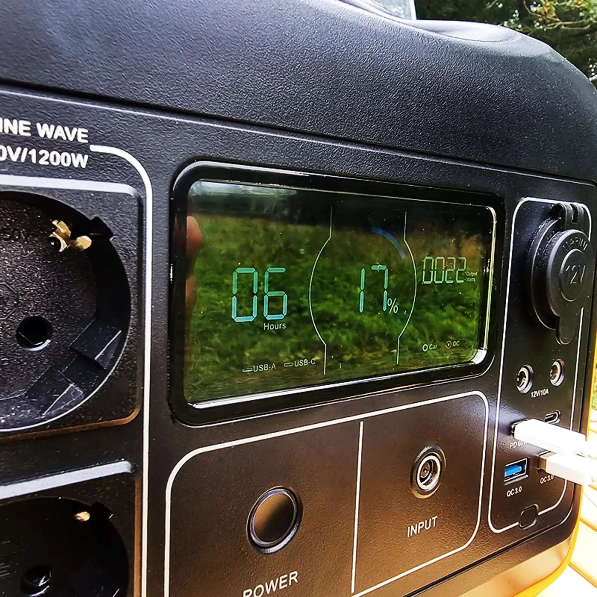 Portable battery kit with solar panel, displaying power and charge level on digital screen, ideal for travel and outdoor use.
