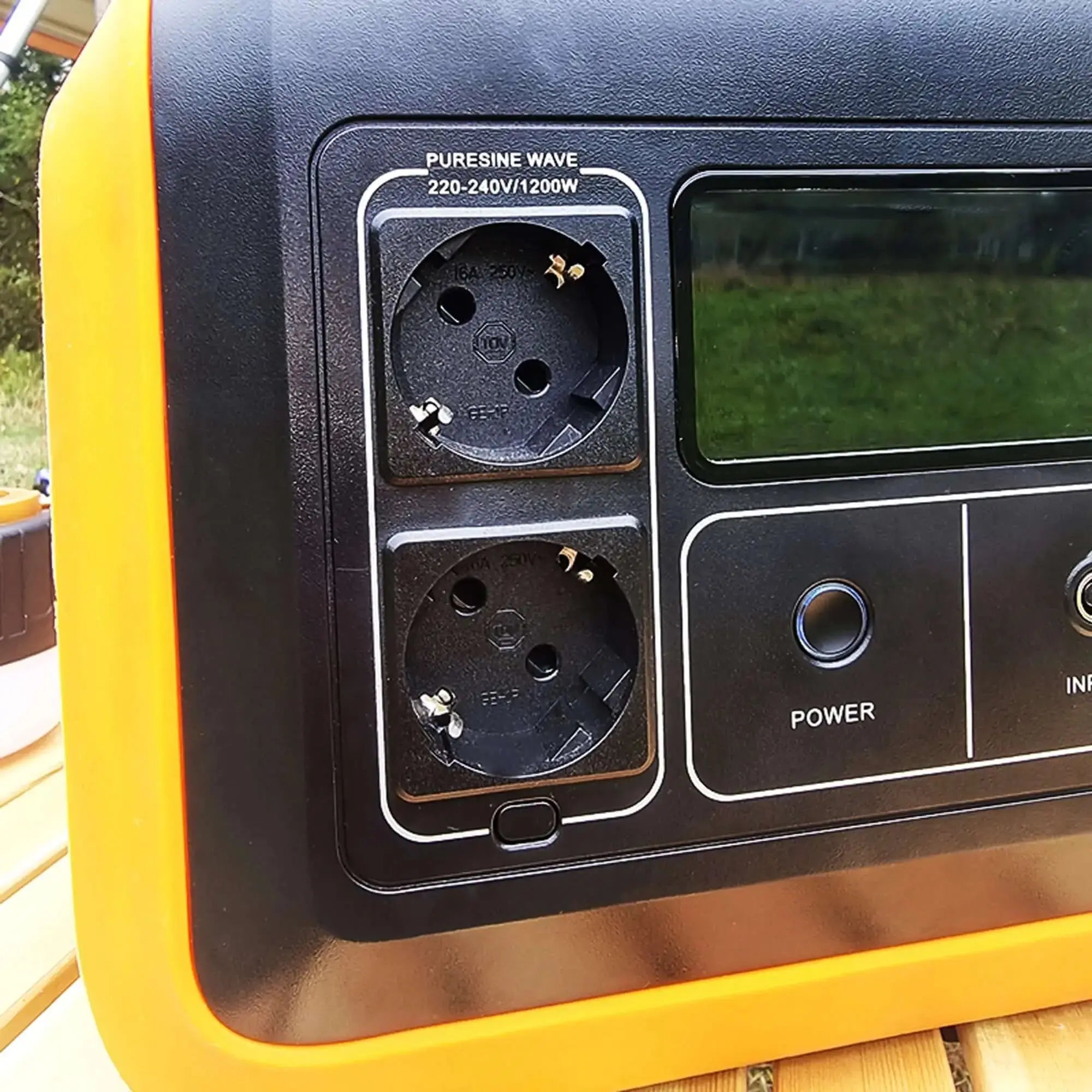 Close-up of Woody's Camp portable battery with power outlets and display, designed for travel with solar panel compatibility.