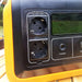 Gros plan de la batterie portable Woody's Camp avec prises électriques et écran, conçue pour les voyages avec une compatibilité de panneaux solaires.