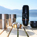location louer une  Machine à café à capsules espresso portable avec des tasses en acier inoxydable sur une table en bois, idéale pour les voyages et le camping.