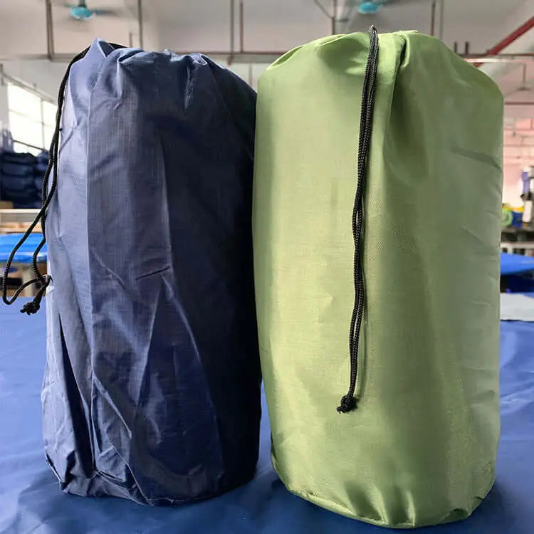 Two packed inflatable camping mattress bags, one blue and one green, placed indoors for compact storage and easy transport.