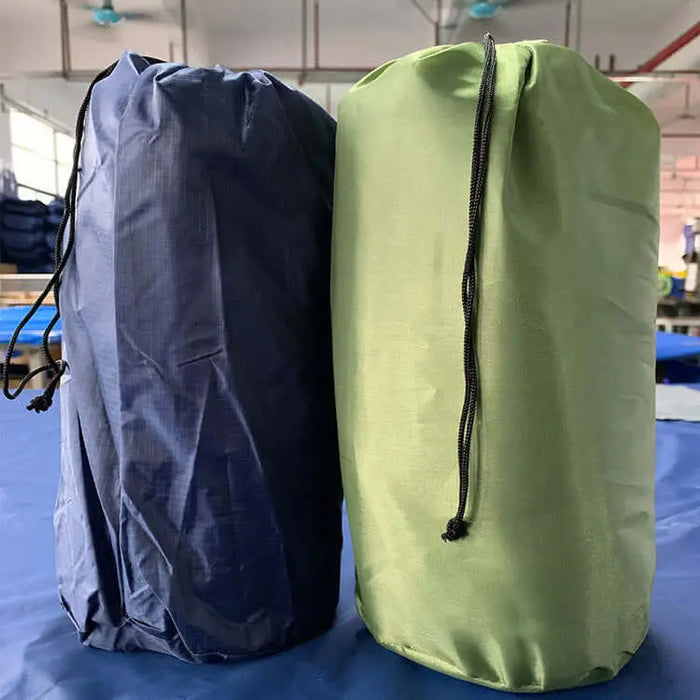 Deux sacs de matelas de camping gonflables, l'un bleu et l'autre vert, placés à l'intérieur pour un stockage compact et un transport facile.