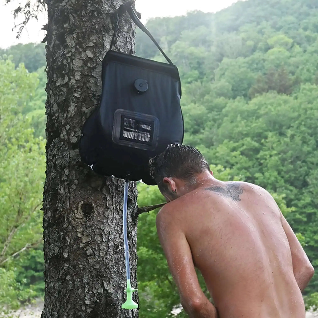 Man using 20L solar shower bag outdoors, ideal for camping, hiking, and eco-friendly adventures.