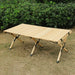 Table de camping en bois pliable installée en plein air, avec des charnières durables pour un rangement facile.