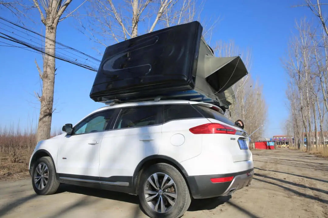 Car equipped with a rigid rooftop tent for 2-3 people, parked outdoors, ideal for family camping adventures and comfortable sleep.